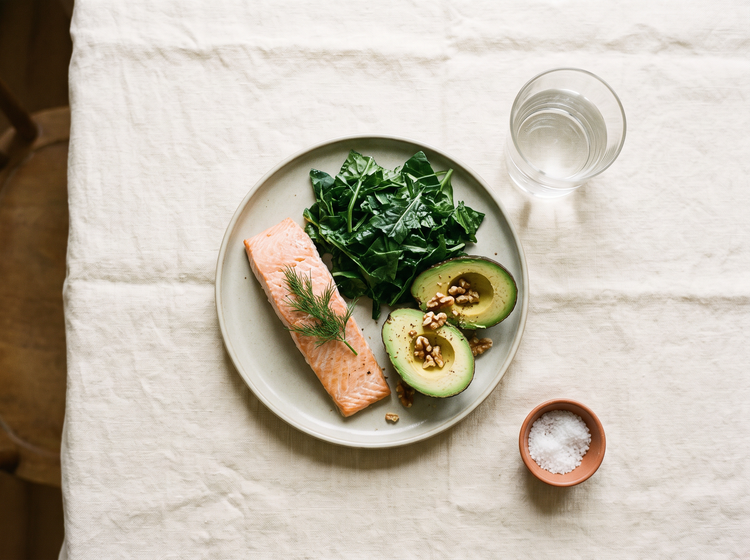 Balanced everyday meal of greens, salmon, avocado and walnuts